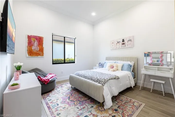 Bedroom featuring ornamental molding, wood finished floors, and recessed lighting