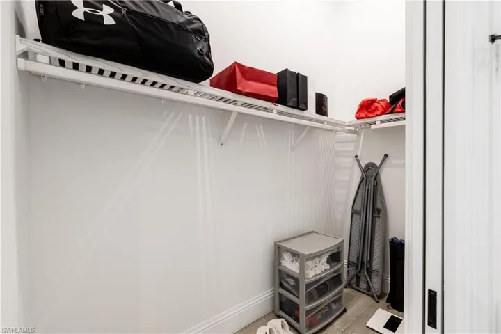Walk in closet with light wood-style floors