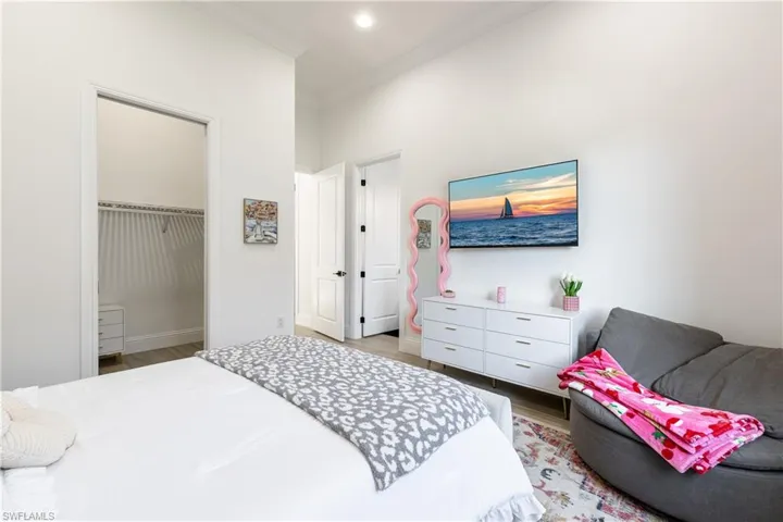 Bedroom featuring ornamental molding, light wood-style floors, a spacious closet, and recessed lighting