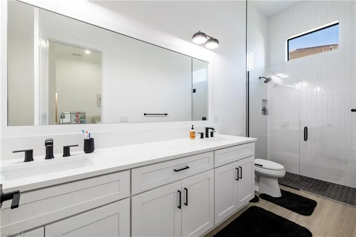 Bathroom featuring double vanity and a stall shower