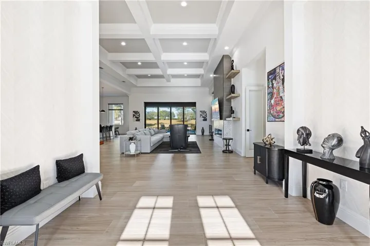 Entrance foyer featuring coffered ceiling, light wood-style floors, an accent wall, recessed lighting, and wallpapered walls