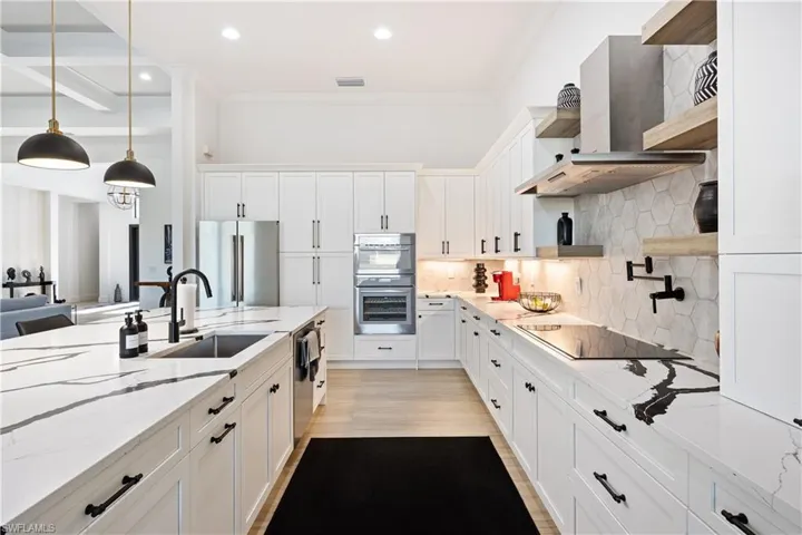 Kitchen with open shelves, backsplash, light stone countertops, white cabinetry, and crown molding