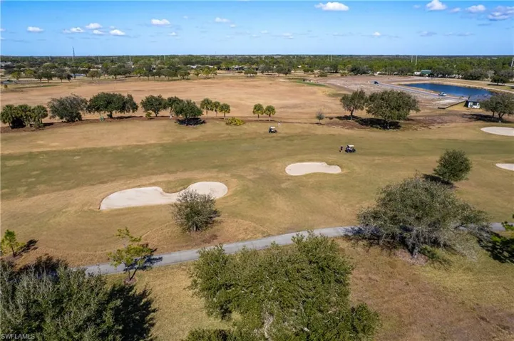 Drone / aerial view of a golf course and a nearby body of water