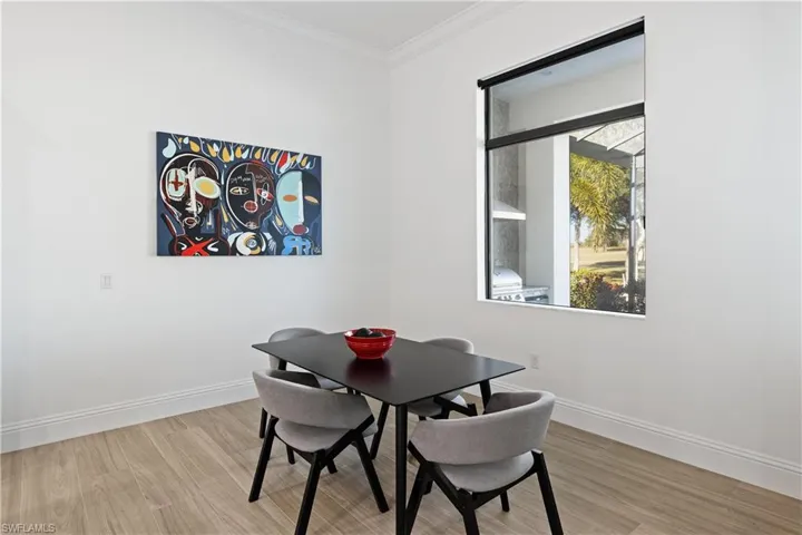 Dining area with crown molding and light wood finished floors