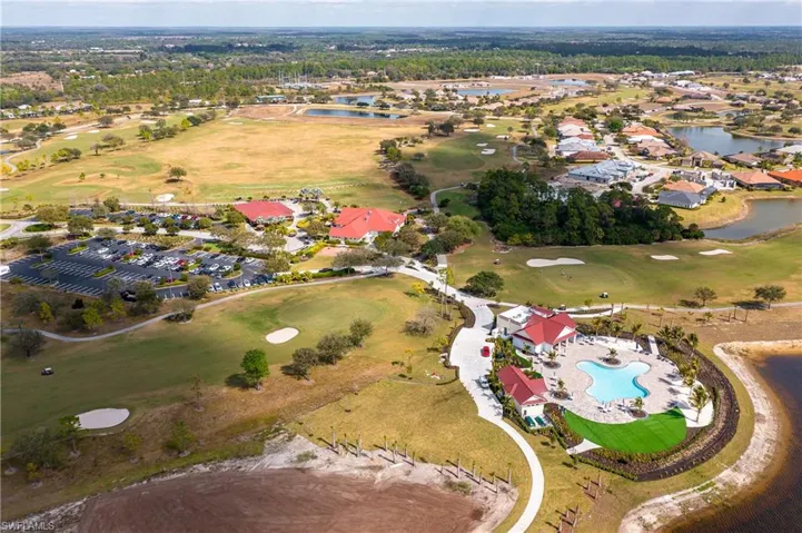 Aerial view of property and surrounding area with a nearby body of water, a local golf course, and nearby suburban area