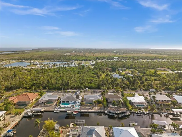Aerial view of property and surrounding area with a large body of water and nearby suburban area
