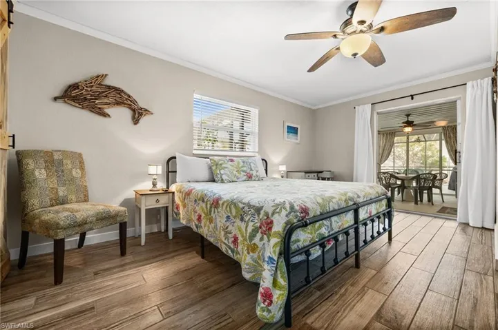 Bedroom featuring access to outside, ornamental molding, hardwood / wood-style flooring, and ceiling fan