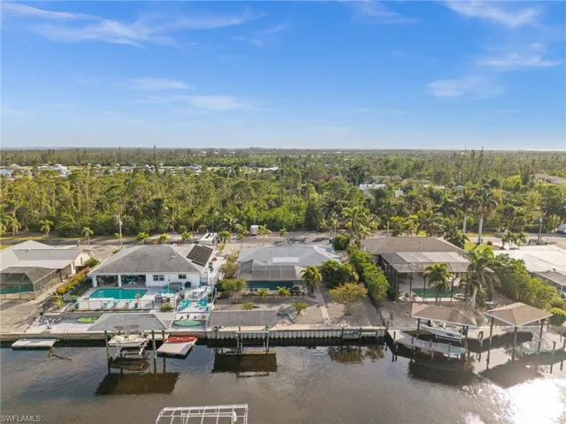 Aerial perspective of suburban area with a nearby body of water and a pool