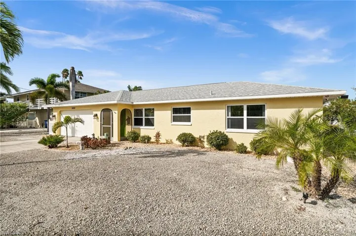 View of front facade with an attached garage, stucco siding, concrete driveway, and roof with shingles