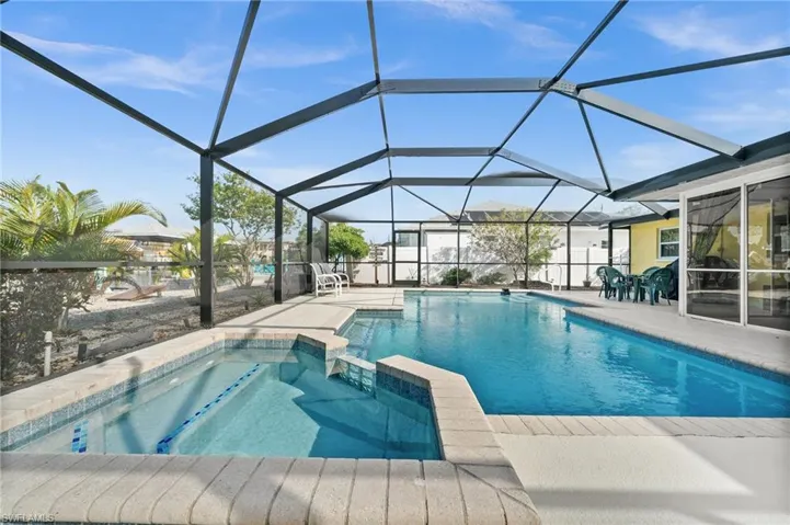 View of pool featuring a pool with connected hot tub, a sunroom, a lanai, and a patio area