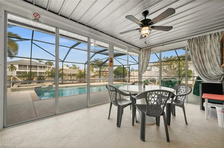 Sunroom featuring a jacuzzi, a ceiling fan, outdoor dining space, and a patio