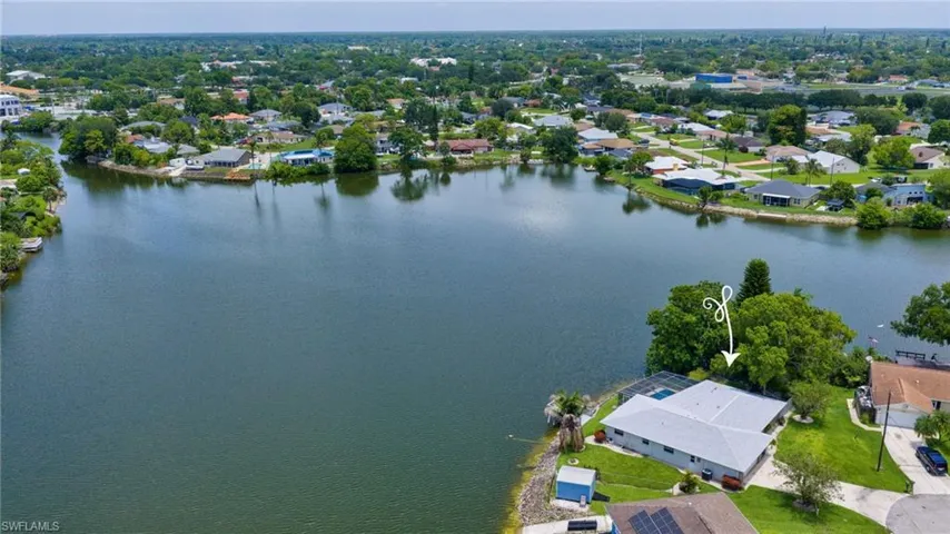 Waterfront property featuring a single-story residence with a light-colored roof
