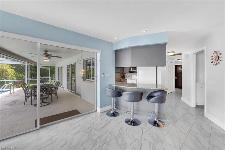 Expansive screened patio featuring a ceiling fan, outdoor dining space, and a pool area