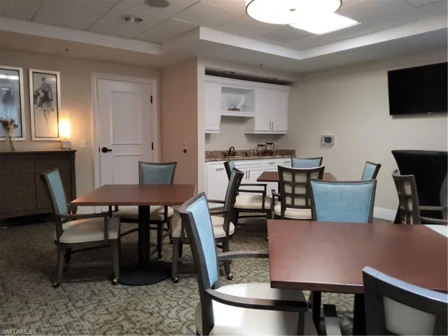 Dining area with a drop ceiling, a tray ceiling, and light carpet