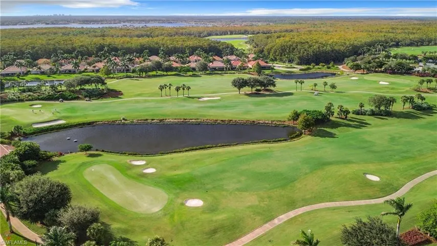 Aerial view of residential area with a nearby body of water and a golf course