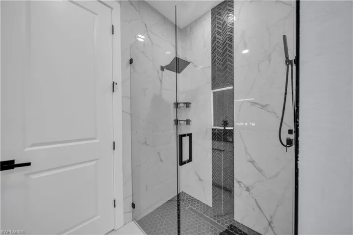 Full bath featuring a marble finish shower