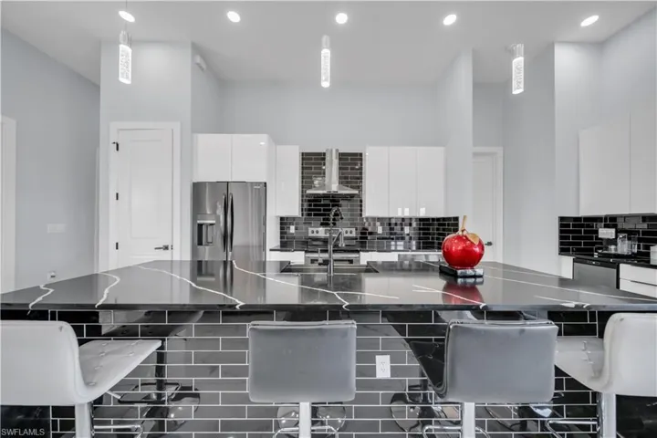 Kitchen with a breakfast bar, stainless steel appliances, and white cabinets