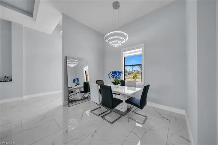Dining area with suspended lighting and a high ceiling
