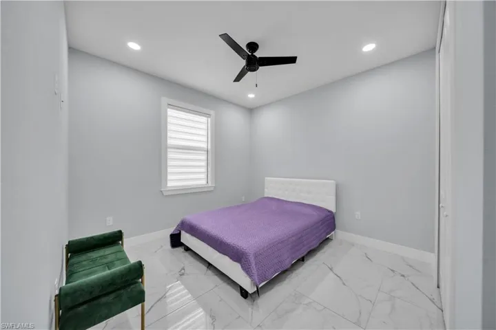 Bedroom with recessed lighting, ceiling fan, and light marble finish flooring
