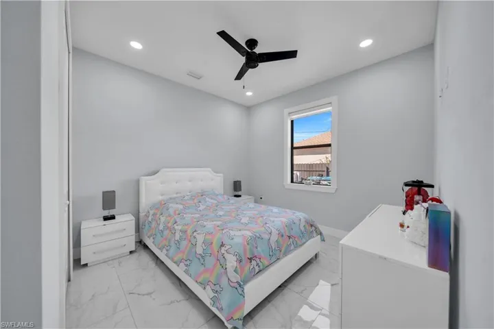 Bedroom with recessed lighting, a ceiling fan, and light marble finish flooring