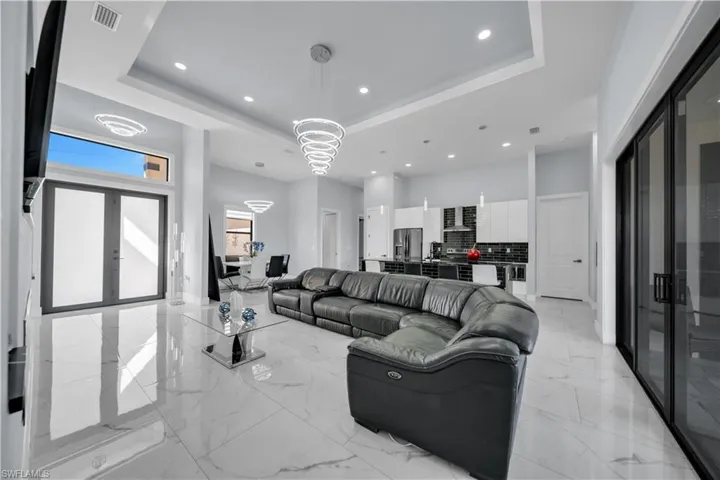 Living room with recessed lighting, french doors, and a high tray ceiling