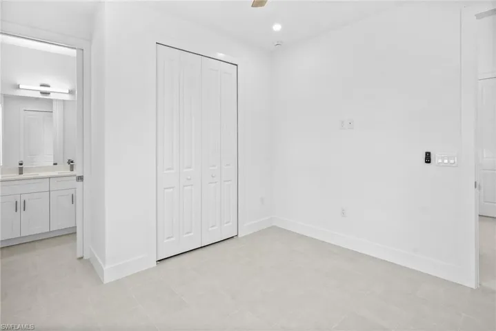 Unfurnished bedroom featuring a closet, ceiling fan, connected bathroom, and recessed lighting