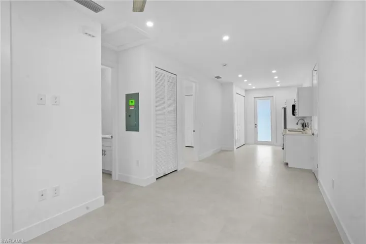 Hall featuring recessed lighting and electric panel