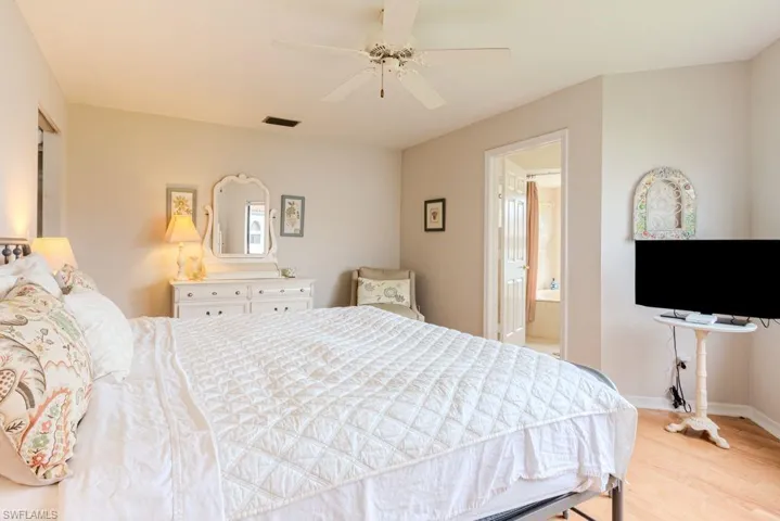Bedroom featuring ensuite bath, ceiling fan, and light hardwood / wood-style flooring