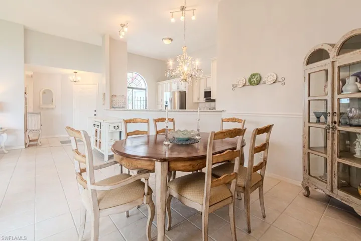 Dining space featuring light tile patterned floors and an inviting chandelier