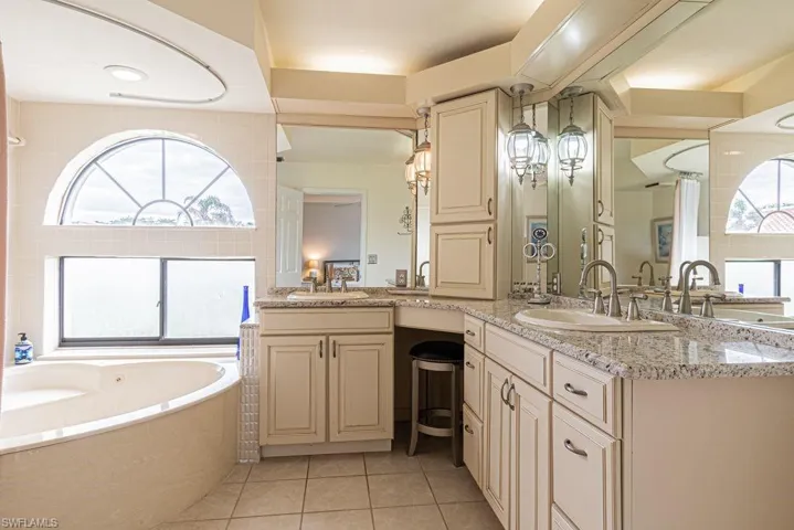 Bathroom with a bathtub, tile patterned flooring, and vanity