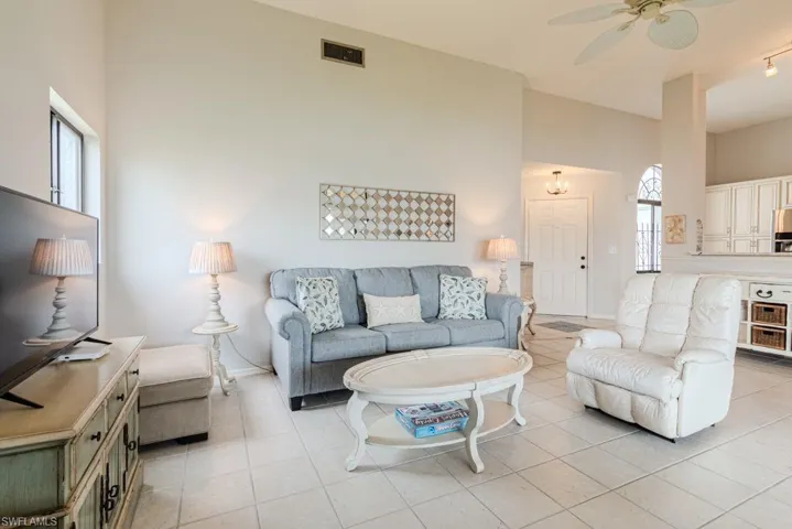 Living room with ceiling fan and light tile patterned floors