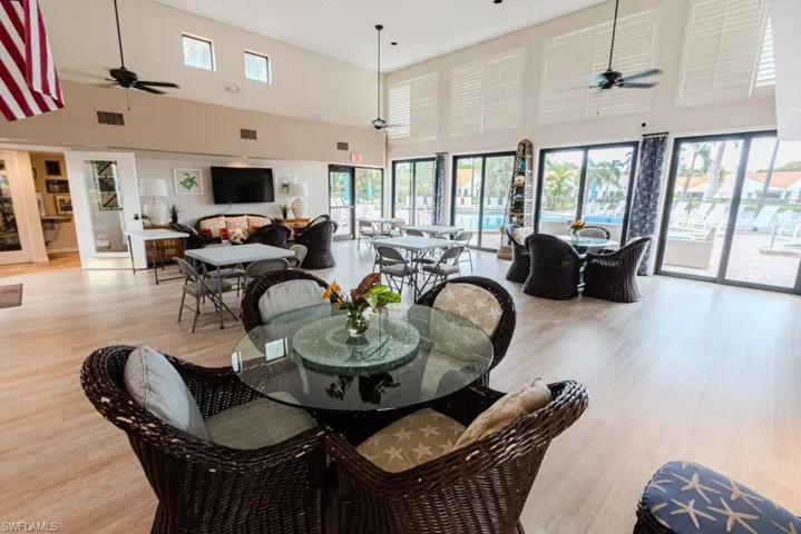 Dining room with a high ceiling, light hardwood / wood-style flooring, and ceiling fan