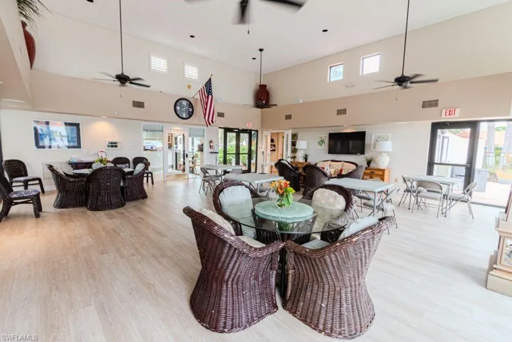 Dining space with a towering ceiling, light hardwood / wood-style floors, and ceiling fan