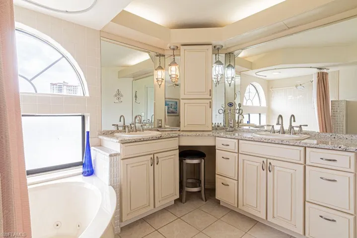 Bathroom featuring tile patterned flooring, vanity, and a washtub