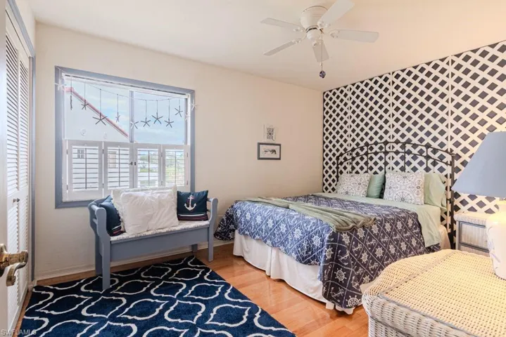 Bedroom with hardwood / wood-style flooring, ceiling fan, and a closet