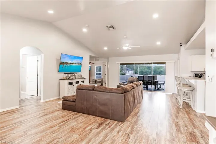 Living area featuring  light wood-style floors, cathedral ceiling, recessed lighting and a ceiling fan