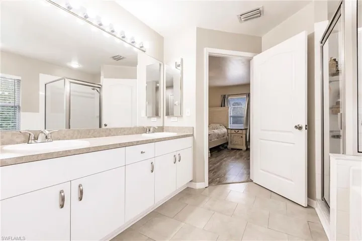 Ensuite bathroom featuring double vanity, double sinks and a large shower stall