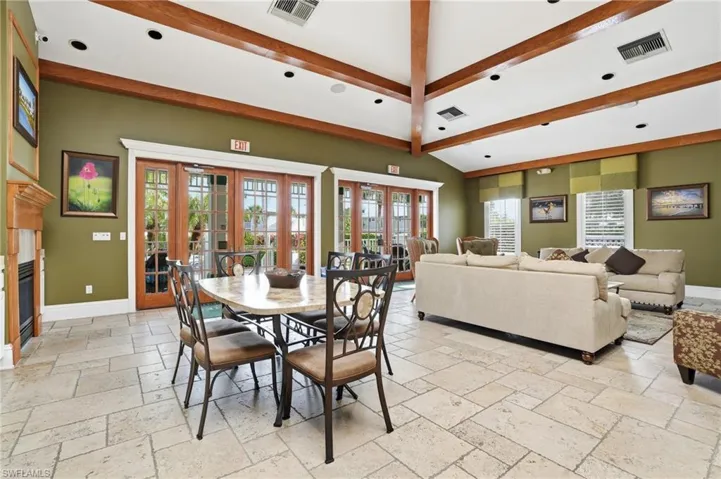 Dining room with a glass covered fireplace, stone tile floors, recessed lighting, and french doors