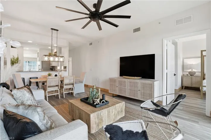 Living area with wood finished floors, ceiling fan, and recessed lighting