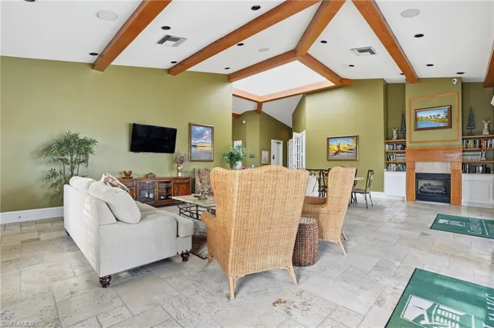 Living room featuring a tiled fireplace and stone tile floors