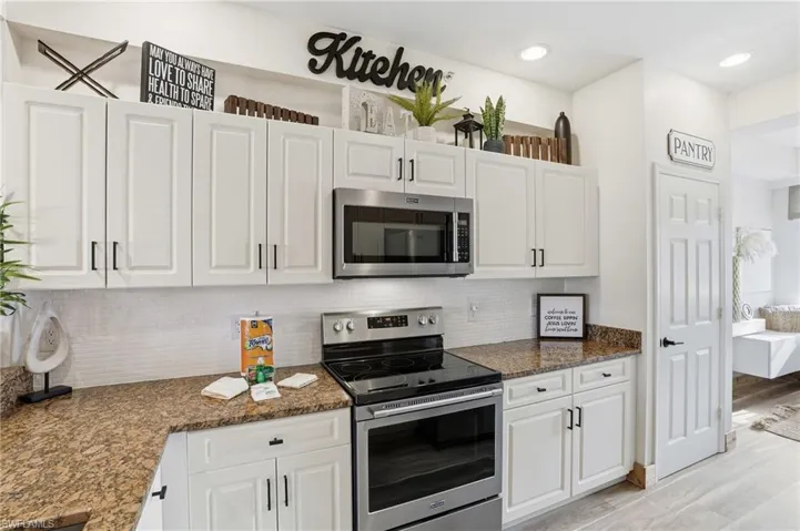 Kitchen featuring stainless steel appliances, tasteful backsplash, white cabinets, and recessed lighting