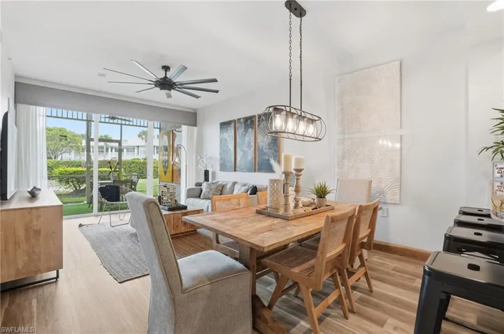 Dining room with light wood-type flooring, ceiling fan, and a chandelier