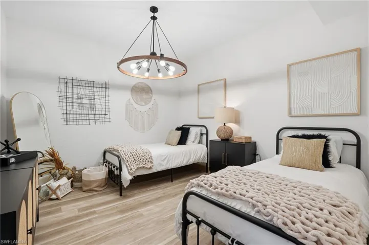 Bedroom with light wood-type flooring and a chandelier