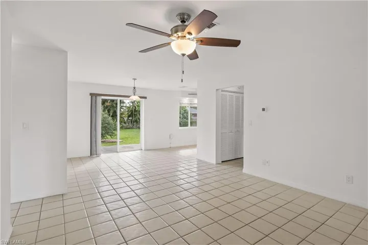 Empty room featuring light tile patterned floors and ceiling fan