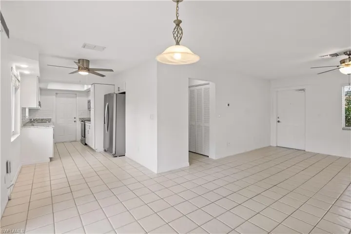 Empty room featuring ceiling fan and light tile patterned flooring