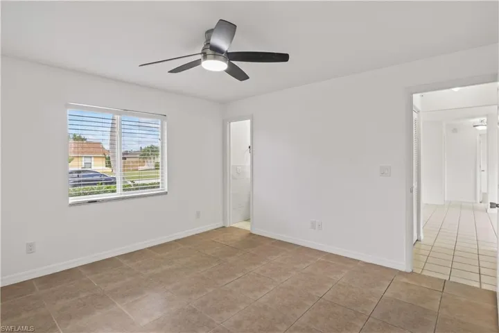 Unfurnished room featuring light tile patterned flooring and ceiling fan