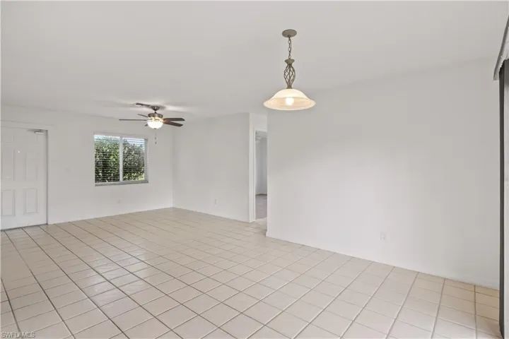 Unfurnished room with light tile patterned floors and ceiling fan