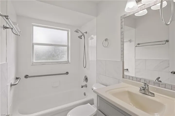 Full bathroom featuring  shower combination, tile walls, and vanity