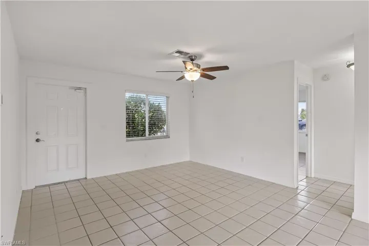 Unfurnished room featuring light tile patterned flooring and a ceiling fan