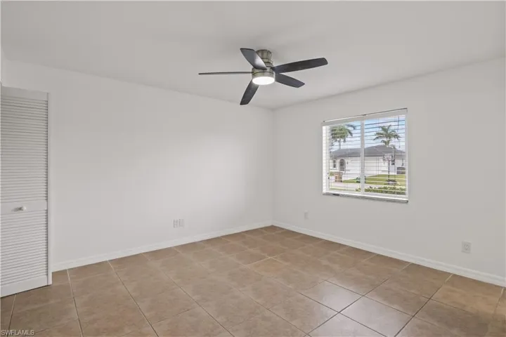 Unfurnished room with light tile patterned floors and ceiling fan